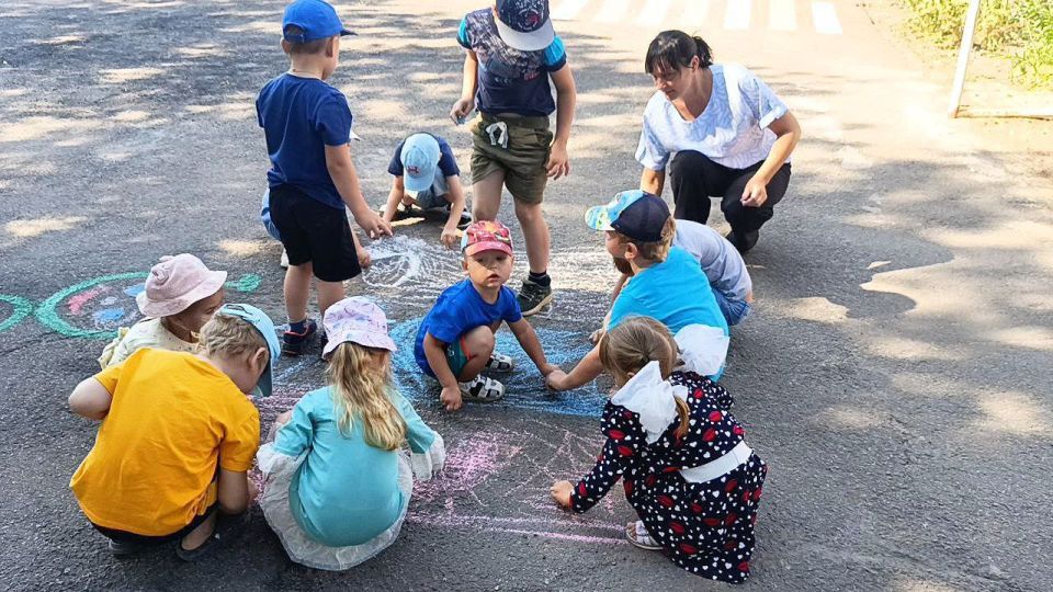 Солнечный денёк, улыбки повсюду, дети смеются, бегают друг за другом и машут маленькими флажками Солнечный денёк, улыбки повсюду, дети смеются, бегают друг за другом и машут маленькими флажками