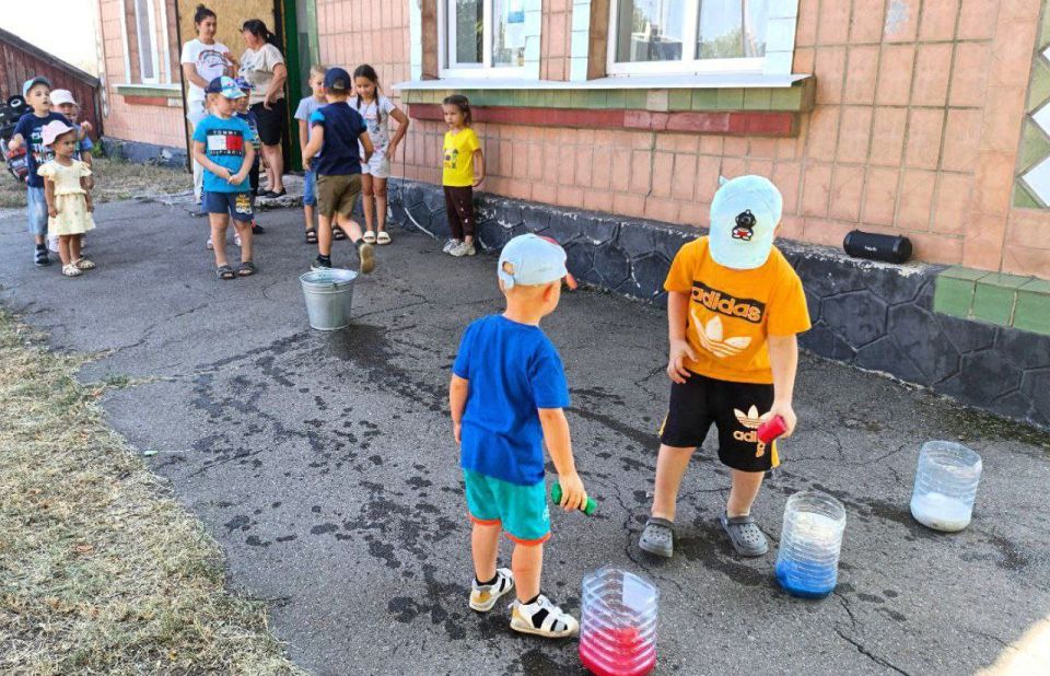 Солнечный денёк, улыбки повсюду, дети смеются, бегают друг за другом и машут маленькими флажками Солнечный денёк, улыбки повсюду, дети смеются, бегают друг за другом и машут маленькими флажками